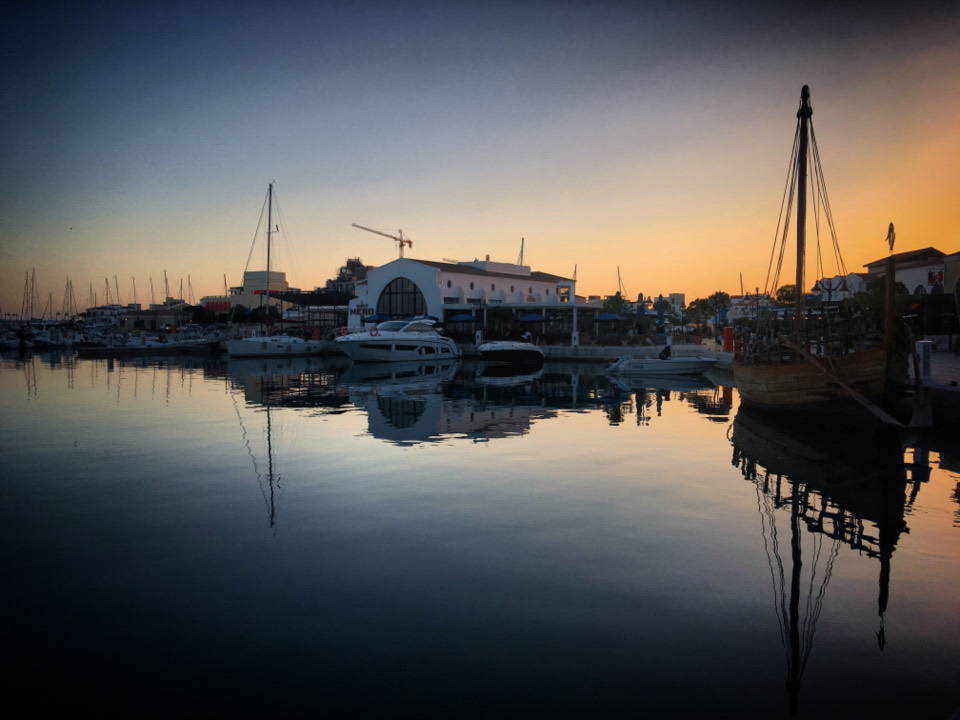 Sailboats in a marina at sunset